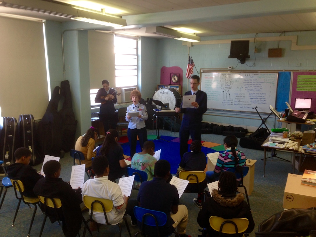 The first Singing Sergeants team, consisting of Senior Master Sgt. Linda Waring and Master Sgt. Emily Wellington and led by Master Sgt. Matthew Irish, teach the national anthem of Japan, "Kimigayo," to ten students at Garrison Elementary School in northwest Washington, D.C. The Singing Sergeants have teamed up with Washington Performing Arts (WPA) to teach local students about world cultures as part of WPA's Embassy Adoption program. (U.S. Air Force photo; released)