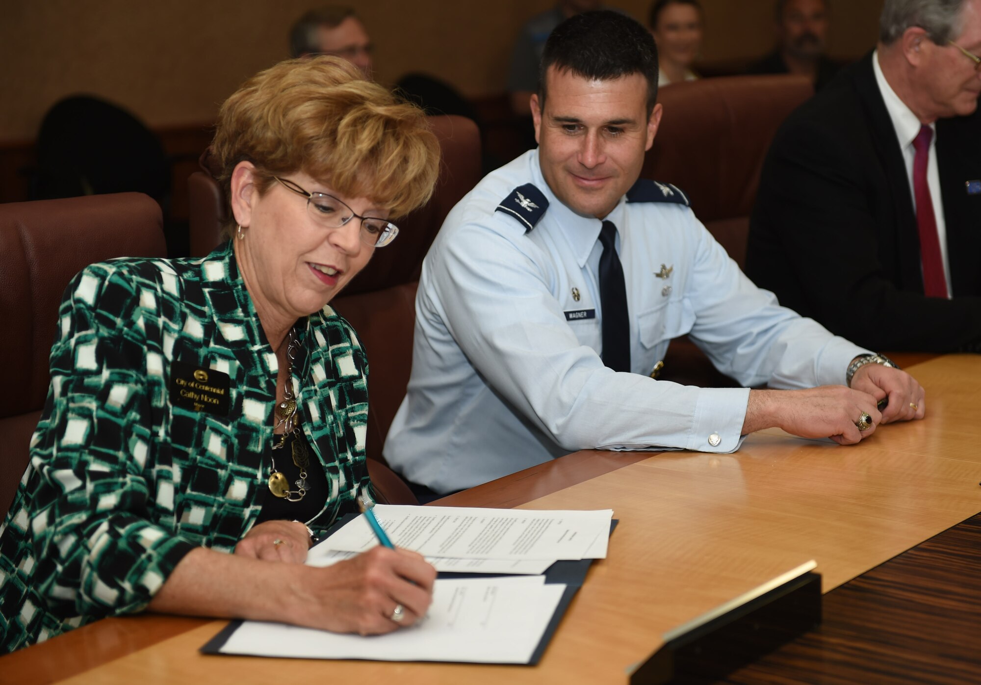 Cathy Noon, Centennial, Colorado mayor, signs the Buckley Partnership Steering Group charter March 31, 2015, at the 460th Space Wing Headquarters building on Buckley Air Force Base, Colo. The document declares partnerships and collaboration between Buckley AFB and local communities. (U.S. Air Force photo by Airman 1st Class Samantha Saulsbury/Released)