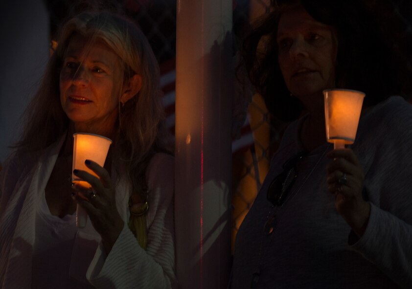 Two women lean on the new flag pole during the Black Hawk UH-60 candlelight memorial service to remember the fallen servicemen March 31 at Destin Executive Airport, Fla.  Approximately 200 from the Destin community held a candlelight memorial service honoring the fallen servicemen in the Black Hawk UH-60 crash in Santa Rosa Sound on March 11.  (U.S. Air Force photo/Tech. Sgt. Jasmin Taylor)