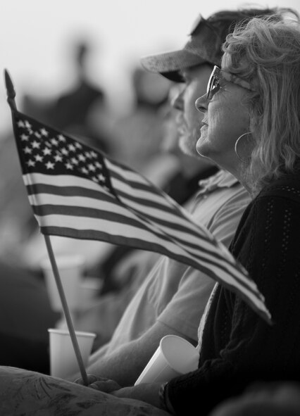 A woman in the crowd waives her flag during the Black Hawk UH-60 memorial service to remember the fallen servicemen March 31 at Destin Executive Airport, Fla.  Approximately 200 from the Destin community held a candlelight memorial service honoring the fallen servicemen in the Black Hawk UH-60 crash in Santa Rosa Sound on March 11.  (U.S. Air Force photo/Tech. Sgt. Jasmin Taylor)