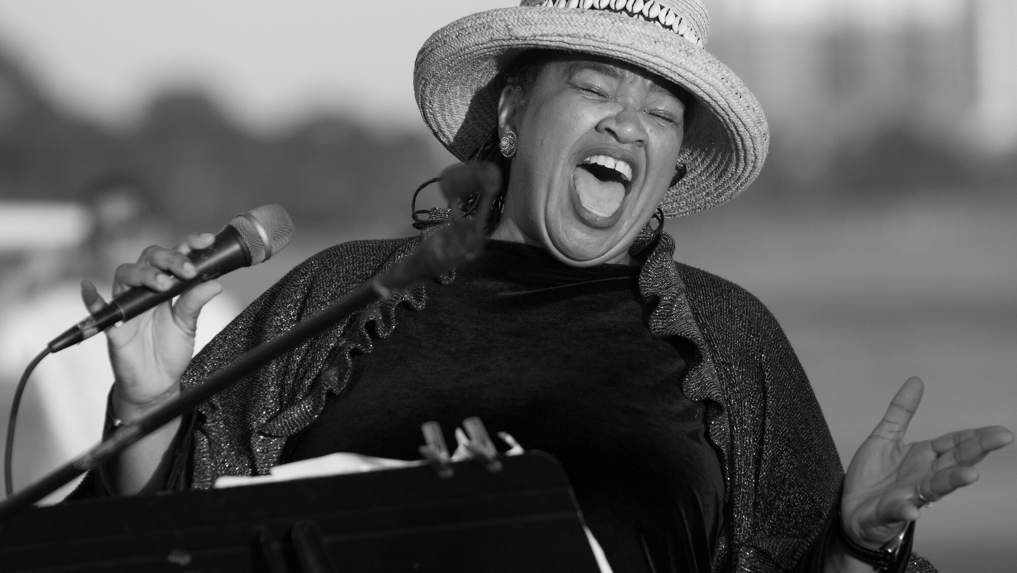 Cheryl Jones, a celebrity entertainer, sings "God Bless America" during the Black Hawk UH-60 memorial service to remember the fallen servicemen March 31 at Destin Executive Airport, Fla.  Approximately 200 from the Destin community held a candlelight memorial service honoring the fallen servicemen in the Black Hawk UH-60 crash in Santa Rosa Sound on March 11.  (U.S. Air Force photo/Tech. Sgt. Jasmin Taylor)