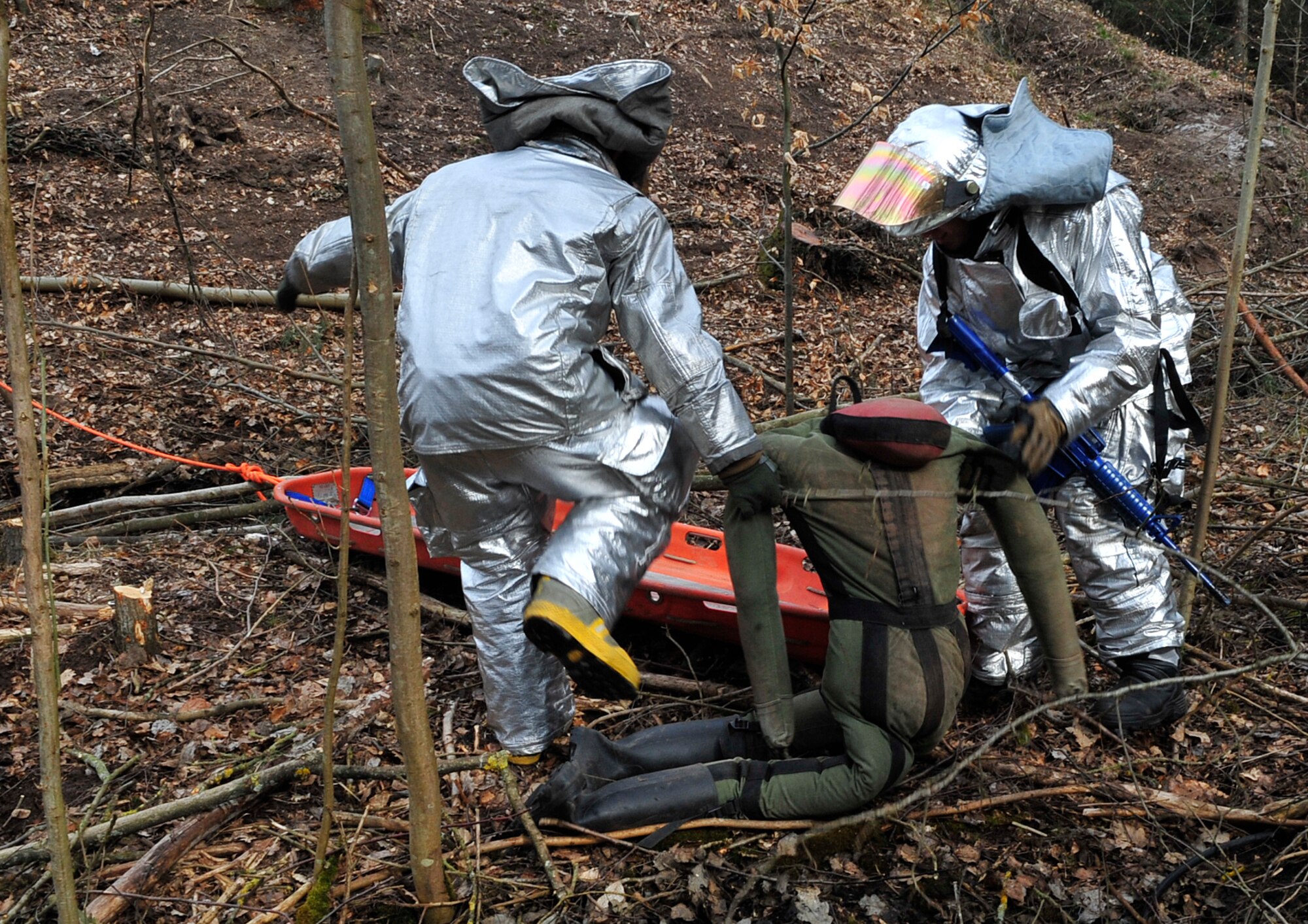 Civil engineer firefighters lift a training dummy in a fire rescue scenario during Silver Flag 2015 exercise training at Ramstein Air Base, Germany, March 21, 2015. Civil engineer Airmen went through hazardous material, fire response and flightline crater repair scenarios to prepare for real wartime situations. (U.S. Air Force photo/Airman 1st Class Larissa Greatwood)