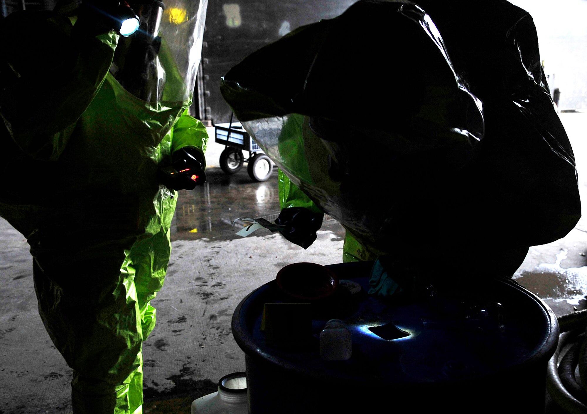 Senior Airman Faisal Farooq, 52nd Civil Engineer Squadron emergency manager, and Airman 1st Class Madeline Setere, 786th Civil Engineer Squadron emergency manager, search a barrel for suspicious substances during a simulated chemical spill during Silver Flag 2015 exercise training at Ramstein Air Base, Germany, March 21, 2015. Civil engineer Airmen went through hazardous material, fire response and flightline crater repair scenarios to prepare for real wartime situations. (U.S. Air Force photo/Airman 1st Class Larissa Greatwood)