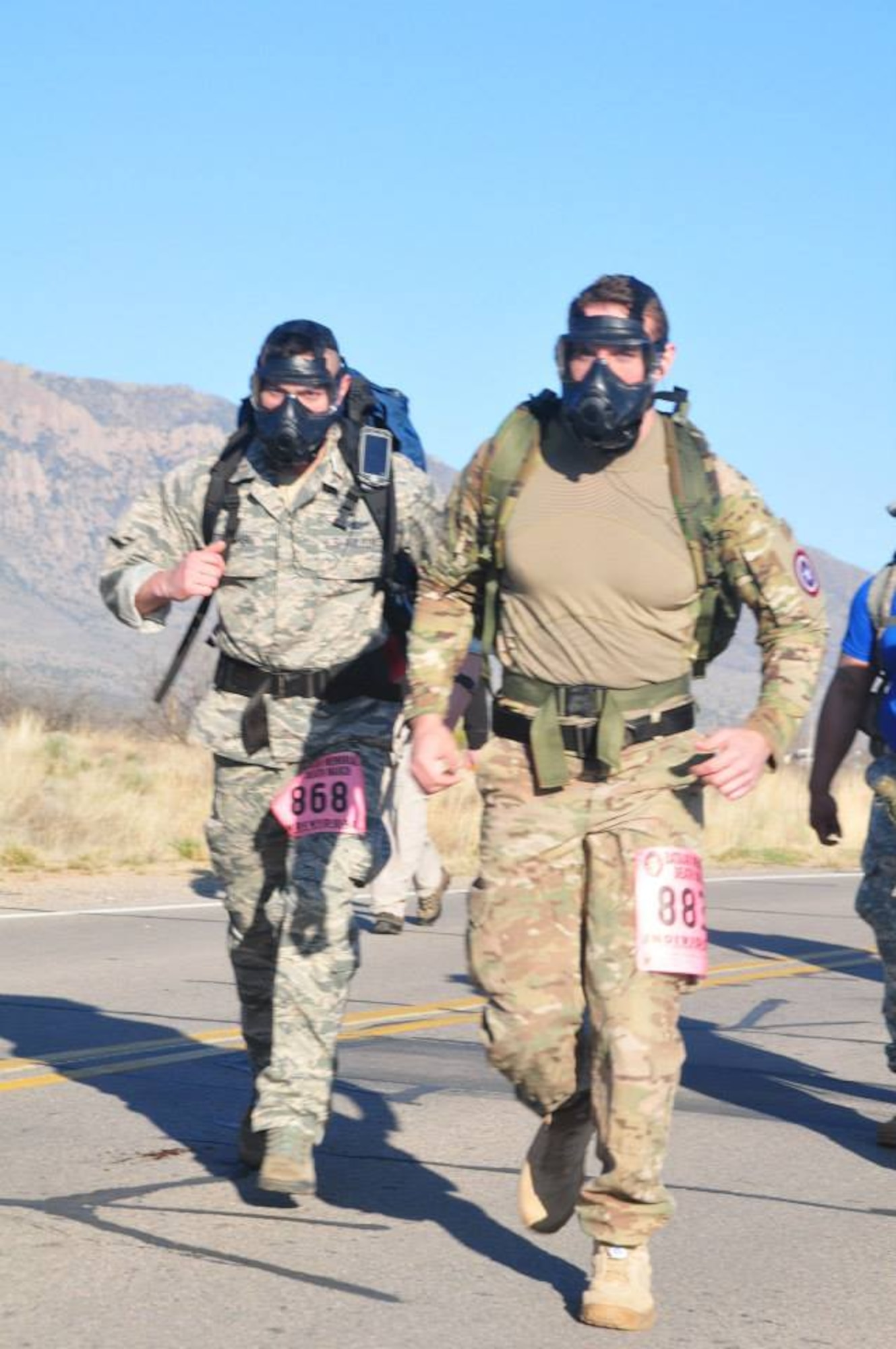 WHITE SANDS MISSILE RANGE, N.M. -- Capt. Steven Meyer and 2nd Lt. Derek Materkowski, 10th Space Warning Squadron, participate in the Bataan Death March Memorial March 22. The pair completed the heavy division, carrying a 35-pound ruck sack the entire 26.2 miles through the desert, and compounded their challenge by choosing to wear a gas mask. (Courtesy photo) 