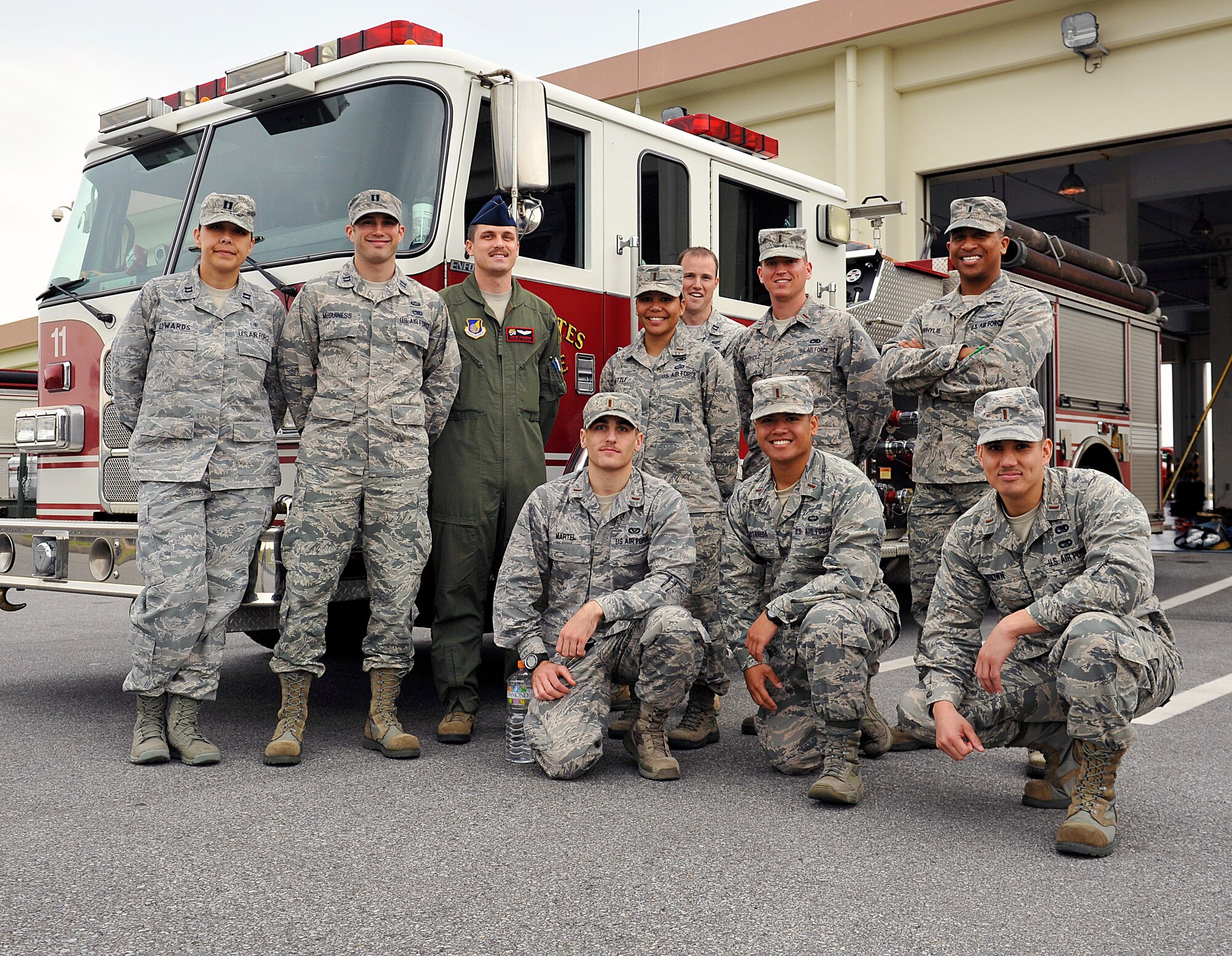 A group of company grade officers pose for a photo in front of a fire truck during the Model Program on Kadena Air Base, Japan, March 25, 2015. The Model Program observed firefighting emergency equipment, hazardous material decontamination, and explosive ordinance disposal with the Kadena Fire Department, and 18th Civil Engineering Squadron Explosive Ordinance Disposal flight. The Model Program allows company grade officers an opportunity to tour various units around Kadena. (U.S. Air Force photo by Naoto Anazawa)


