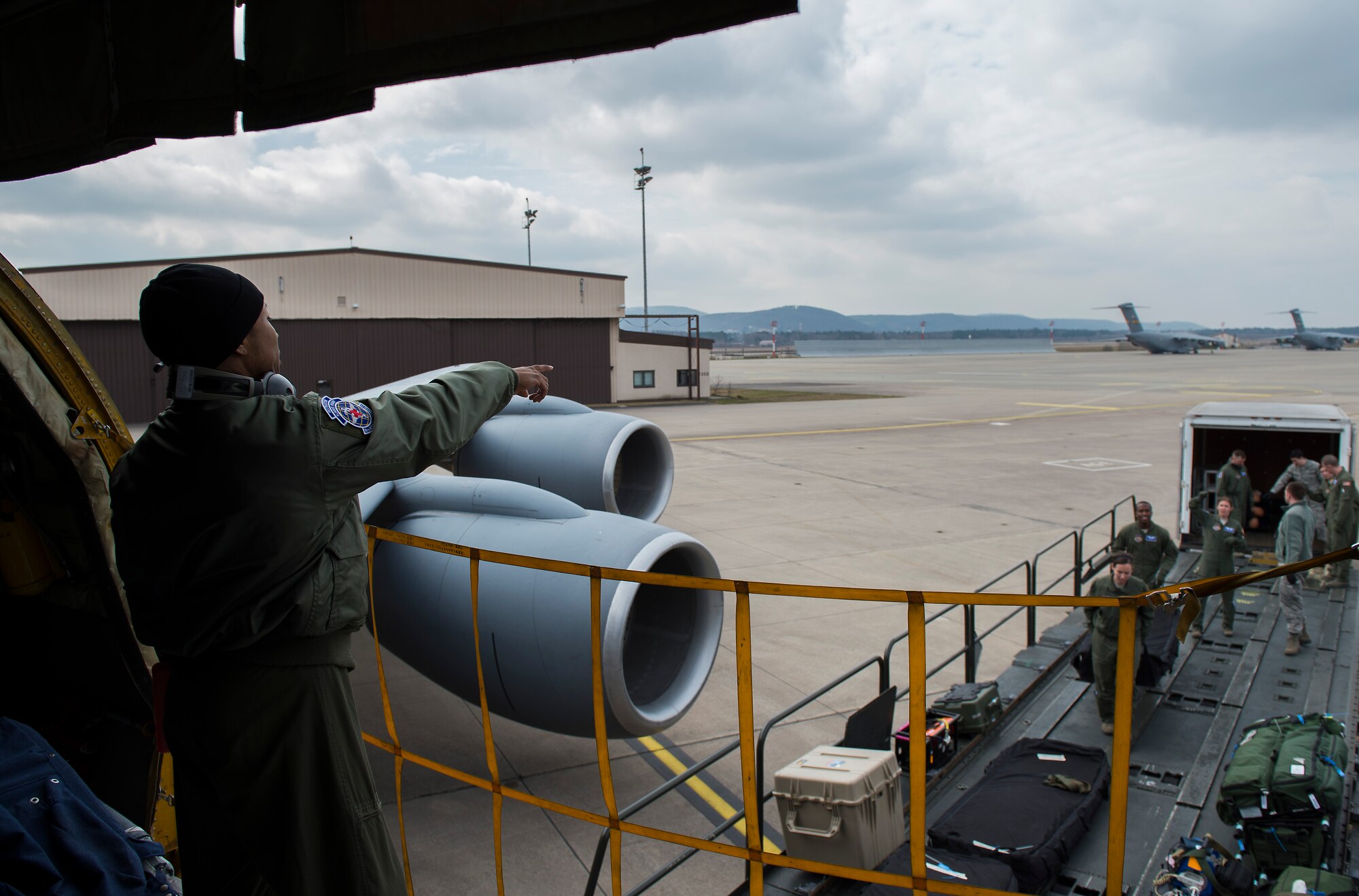 Staff Sgt. Andre Valentine, 86th Aeromedical Evacuation Squadron flight instructor, directs the placement of equipment prior to being loaded on a KC-135 Stratotanker at Ramstein Air Base, Germany, March 26, 2015. Aircrew and a KC-135 from Royal Air Force Mildenhall, England, spent multiple days at Ramstein performing aerial refueling missions, which also gave 86 AES Airmen the opportunity to train on their mission inside a different airframe. (U.S. Air Force photo/Senior Airman Damon Kasberg)