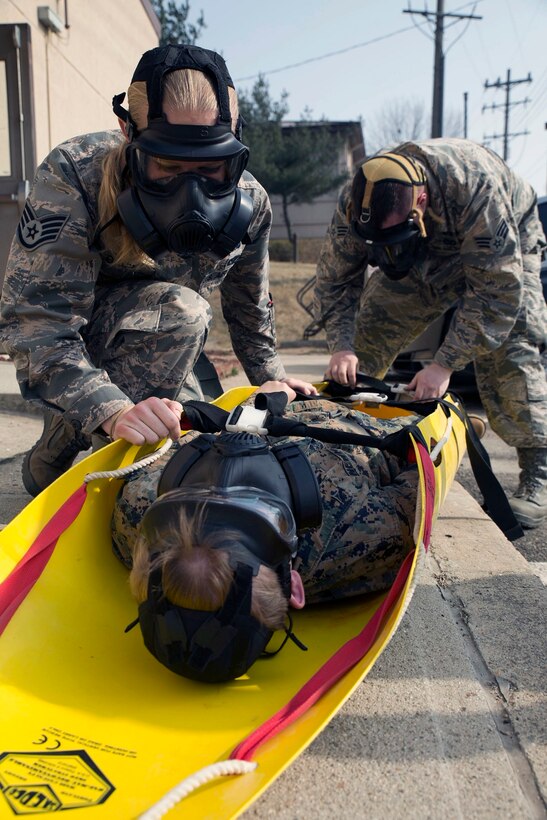 U.S. Marines and airmen extract a simulated casualty at Osan Air Base in the Republic of Korea March 19. Extraction was one of the response scenarios during a chemical, biological, radiological and nuclear joint training exercise with Marine Wing Headquarters Squadron 1 CBRN and 51st Civil Engineer Squadron CBRN. The week-long bilateral training event enabled Marines and airmen to learn different tactics, techniques and procedures. 