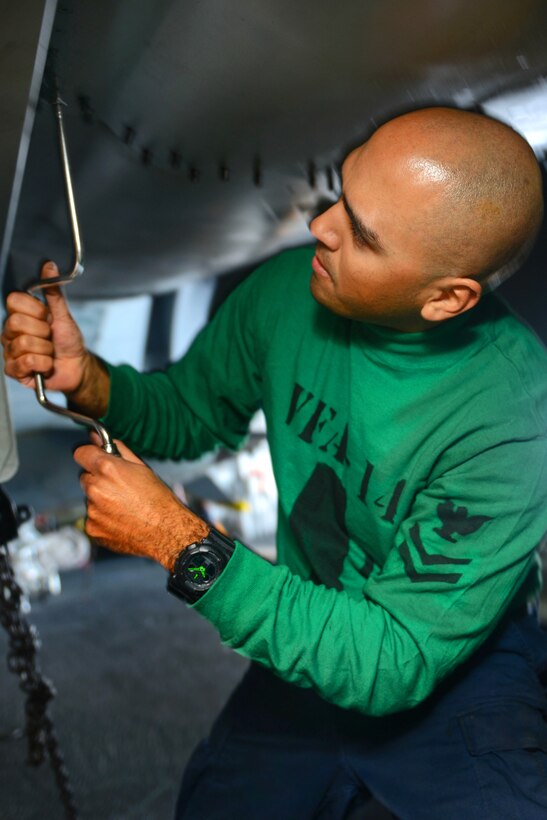 U.S. Navy Petty Officer 2nd Class Frank Cortinas conducts an 84-day inspection on an F/A-18E Super Hornet from the Tophatters of Strike Fighter Squadron 14 aboard the USS John C. Stennis in the Pacific Ocean, March 31, 2015. Cortinas is an aviation electrician's mate.