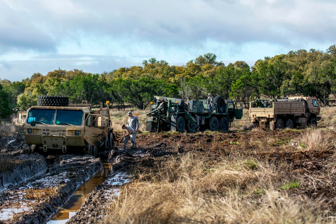 Soldiers help recover an M984 wrecker truck stuck in mud during a vehicle recovery operation on Camp Bullis, Texas, March 22, 2015.