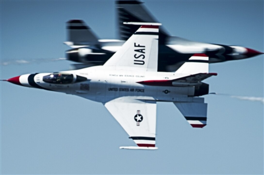 The Thunderbirds solo pilots perform a maneuver, known as the opposing knife-edge pass, during an air show on Keesler Air Force Base, Miss., March 28, 2015. 