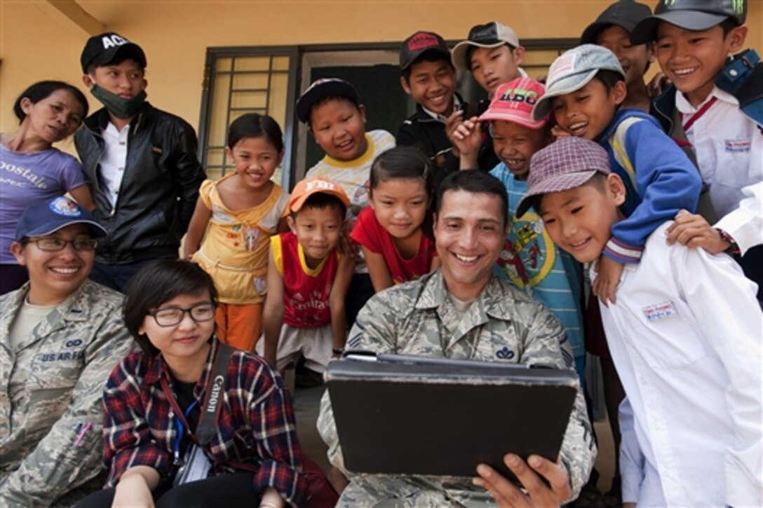 U.S. Air Force Master Sgt. Erick Lizarraga entertains local youths at South Tinh Phong primary school during an engineering project in the Quang Ngai province, Vietnam, March 26, 2015. Efforts undertaken during Operation Pacific Angel 2015 help multilateral militaries in the Pacific improve and build relationships across a wide spectrum of civic operations, bolstering each nation's capacity to respond and support future humanitarian assistance and disaster relief operations. 
