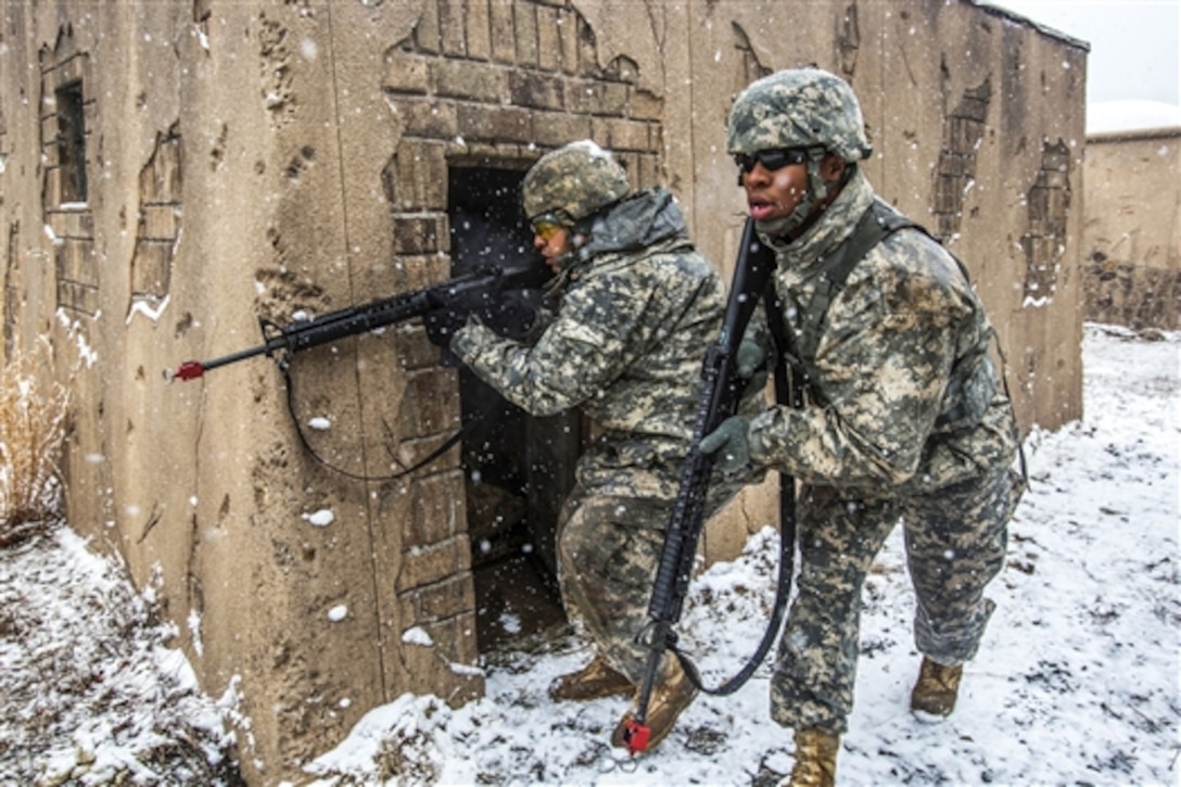 Army Sgt. Wilfredo S. Rodriguez-Ramos, left, provides cover fire as Army Pfc. Emery L. Bowens moves between buildings during battle drills at the training site for military operations in urban terrain on Joint Base McGuire-Dix-Lakehurst, N.J., March 20, 2015. Rodriguez-Ramos and Bowens are military police officers assigned to the New Jersey Army National Guard's 328th Military Police Company. 
 