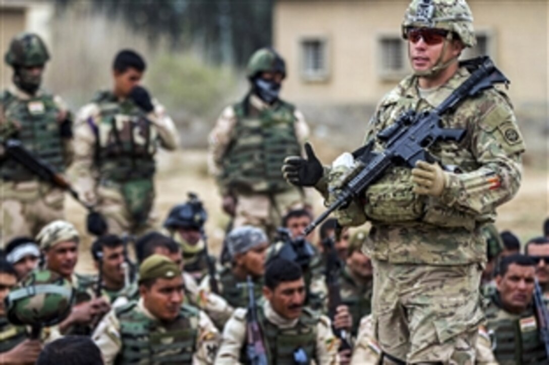 A U.S. cavalry scout explains squad-level movement techniques to about 250 Iraqi soldiers on Camp Taji, Iraq, March 24, 2015. The scout is assigned to the 82nd Airborne Division's 5th Squadron, 73rd Cavalry Regiment, 3rd Brigade Combat Team. The unit was deployed to Iraq as part of Combined Joint Task Force Operation Inherent Resolve to advise and assist Iraqi forces in their fight against the Islamic State of Iraq and the Levant. 
