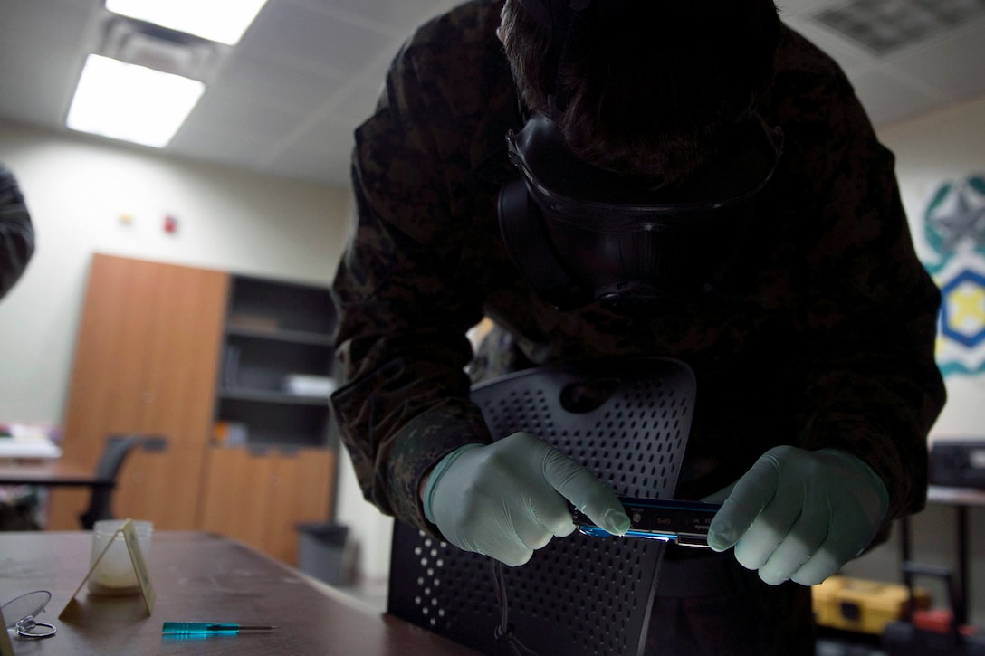 U.S. Marine Cpl. Donald L. Harmon, a Cleveland, Ohio, native, takes a picture of evidence at Osan Air Base in the Republic of Korea March 19. Scene preservation was one of the response scenarios during a chemical, biological, radiological and nuclear joint training exercise with Marine Wing Headquarters Squadron 1 CBRN and 51st Civil Engineer Squadron CBRN. The week-long bilateral training event enabled Marines and airmen to learn different tactics, techniques and procedures. Harmon is a CBRN Defense Specialist with Marine Wing Headquarters Squadron 1, 1st Marine Aircraft Wing, III Marine Expeditionary Force. (