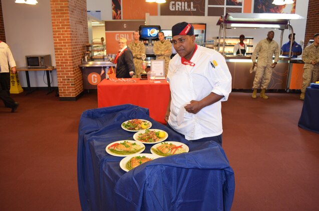 Yolonda Webster, a chef at the Marine Corps Air Facility Quantico chow hall, prepares to serve food to the judges that she and her partner, Stephanie Parker, prepared for the chef of the quarter cooking competition held at Bruce Hall March 25. 