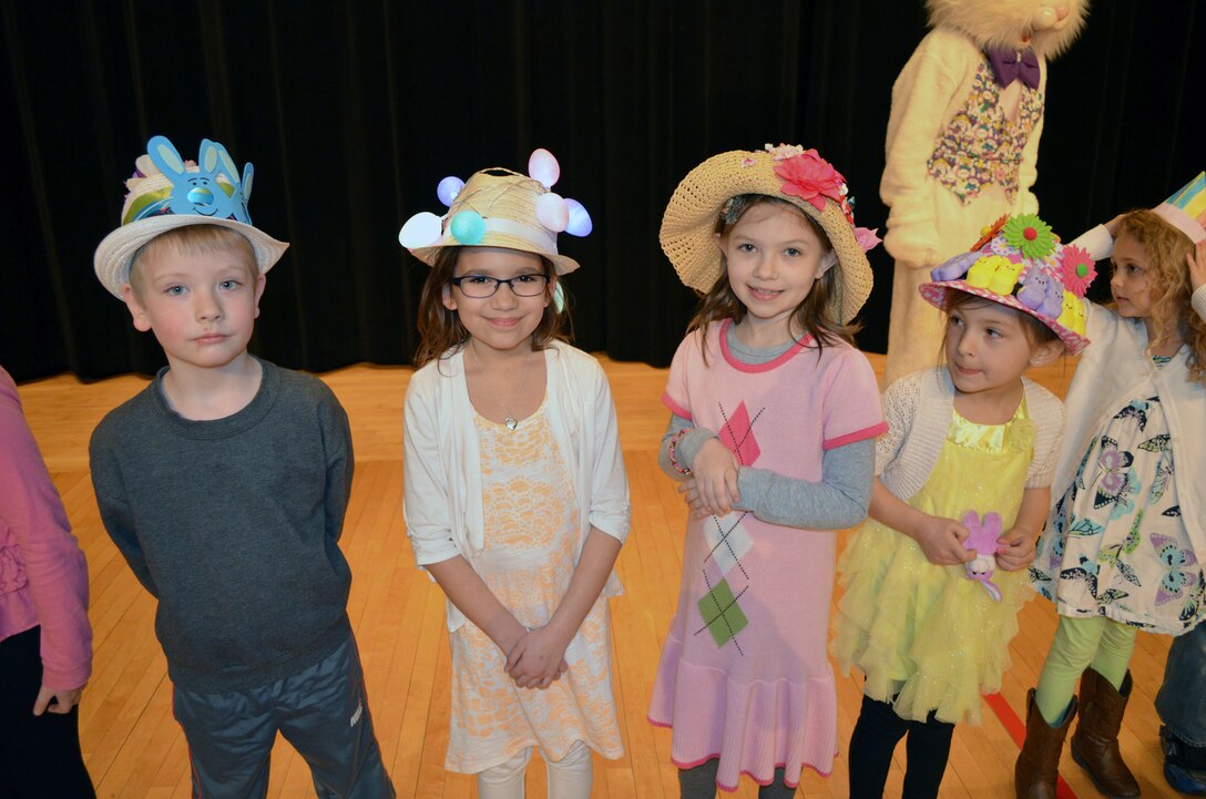 Smiling children wait for the judging to start in the Easter bonnet contest before the Easter egg hunt Saturday on the Little Hall lawn and inside the theater.