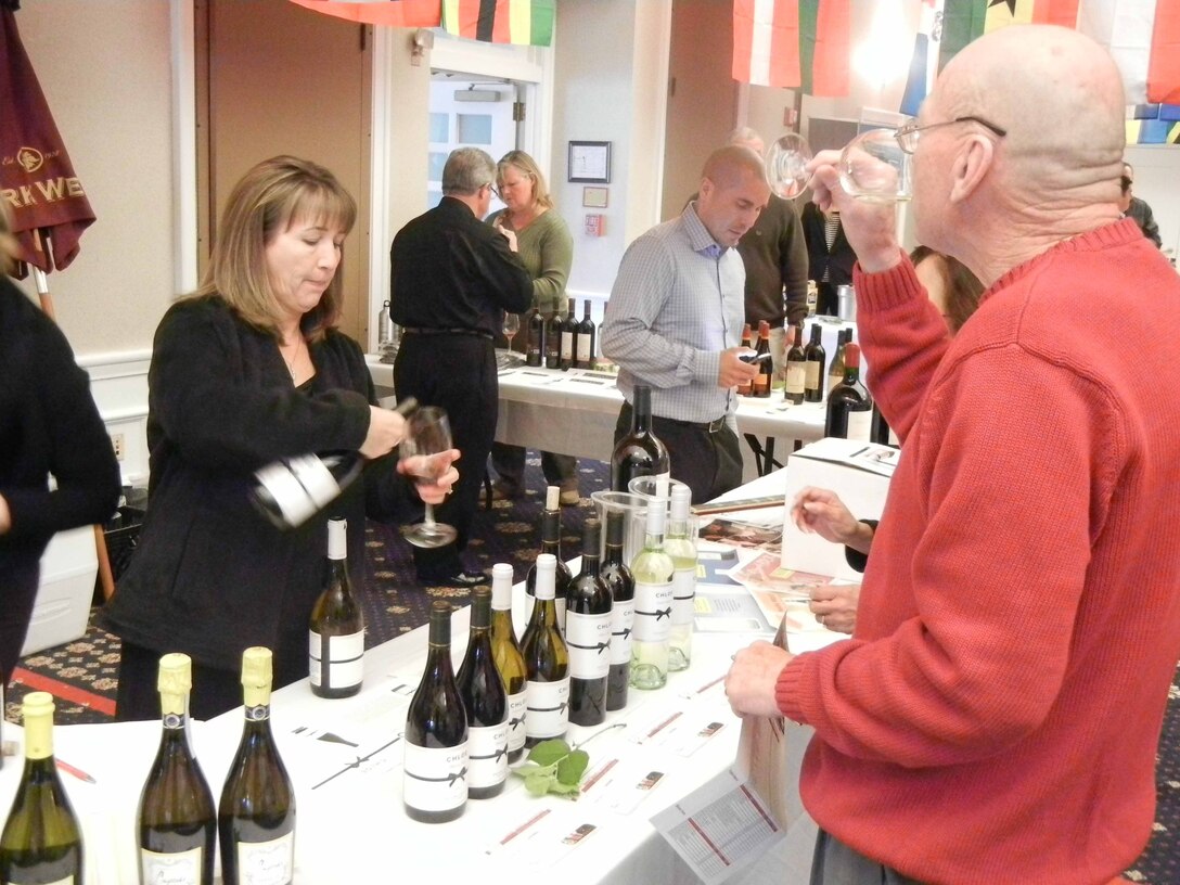 Rhonda Rehard, tasting and marketing consultant, Beaute Agency, pours a glass of wine for retired Air Force veteran Dan Kolpin during the Seventh Annual International Wine and Food Festival held at the Clubs at Quantico on March 27.