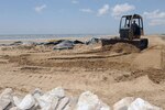 Staff Sgt. Jimmy Lynch of the Louisiana Army National Guard’s, 844th Horizontal Engineer Company, 527th Engineer Battalion, operates a John Deere 650J Bulldozer to level sand on a land bridge behind a rock wall on Elmer's Island, La., July 14, 2010. Soldiers use the smaller dozer, rather than their larger, heavier dozers, because of the increased mobility.