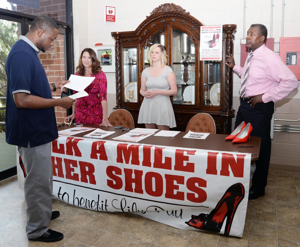 Suzanne Moree (left) and Tiffany Vinson, (center,) both with the Lily Pad Center in Albany, Ga., and Marcus White, Marine Corps Logistics Base Albany's sexual assault response program coordinator, discuss the "Walk A Mile In Her Shoes" campaign with a possible participant, April 2, at the base's restaurant. The campaign will be held April 18 at 10 a.m. at the Deerfield Windsor Upper Campus School in Albany. Men will wear red high heel shoes and walk a mile for victims of sexual assault. Men interested in signing up may visit the booth, which will be at the base restaurant April 9 and 15 from 11 a.m. - 1 p.m. For more information, call 229-639-5252.