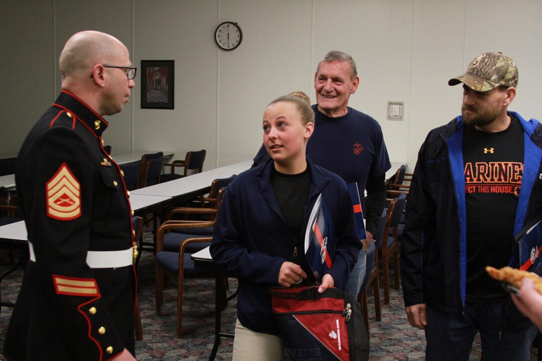 U.S. Marine Corps Gunnery Sgt. Robert Hahn, staff noncommissioned officer in charge of Recruiting Sub-station Huntington and native of Killeen, Texas, speaks with Green Local High School senior Bobbie J. Applegate during an annual Family Night March 23, 2015, at Marshal University campus, Huntington, West Virginia. Applegate, 18, is scheduled to leave for recruit training at Marine Corps Recruit Depot Parris Island, South Carolina, April 5, 2015. She gave up her senior prom and chance to receive her high school diploma alongside her fellow seniors to attend training early. (U.S. Marine Corps photo by Sgt. Caitlin Brink/Released)