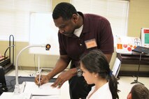 Juan Pace, a licensed architect with the U.S. Army Corps of Engineers Huntsville Center, shows Monte Sano Elementary School student how to maneuver a three-dimensional drawing.