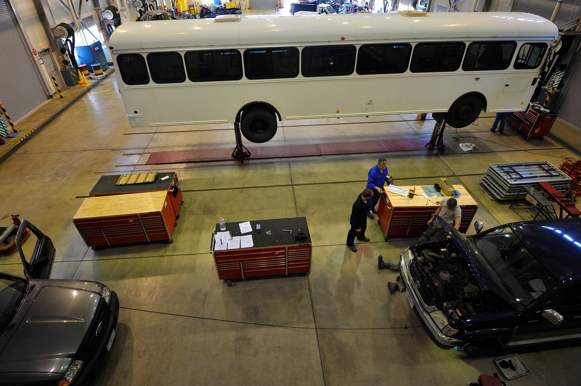 Vehicle maintenance technicians from the 35th Logistics Readiness Squadron discuss equipment required for fixing an axle on a government vehicle at Misawa Air Base, Japan, April 2, 2015. Vehicle maintainers regularly service more than 950 government vehicles and equipment at Misawa. (U.S. Air Force photo by Senior Airman Jose L. Hernandez-Domitilo/Released )