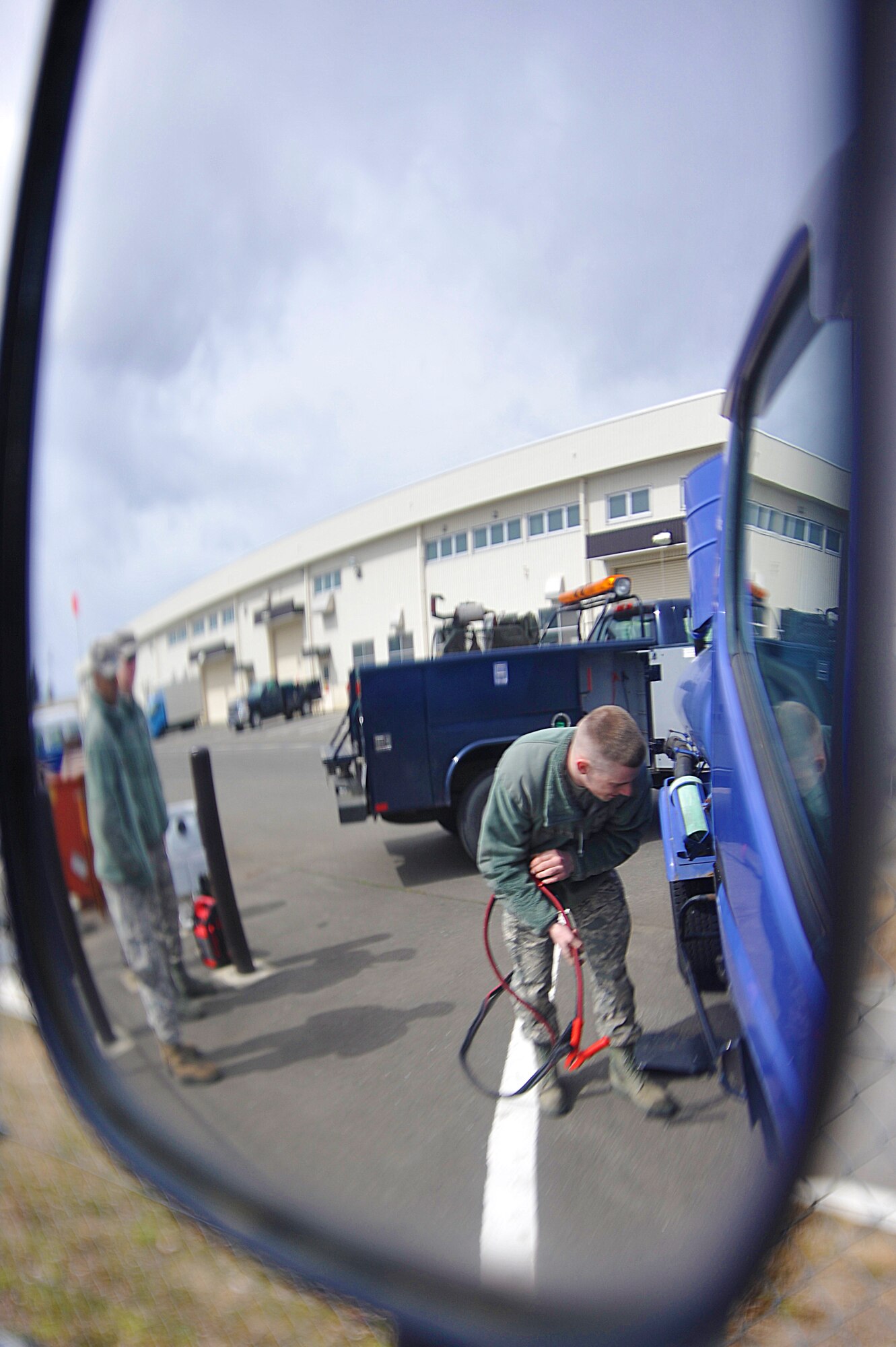 U.S. Air Force Airman 1st Class Brian Pavlinec, 35th Logistics Readiness Squadron vehicle and vehicular maintenance journeyman, prepares to attach jumper cables to the battery of a government vehicle at Misawa Air Base, Japan, March 27, 2015. Pavlinec was responding to a maintenance call at the 35th Civil Engineer Squadron for a vehicle that would not start. The vehicle maintenance flight provides 24/7 on-call mobile service to government vehicles in need of mechanical assistance. (U.S. Air Force photo by Senior Airman Jose L. Hernandez-Domitilo/Released)