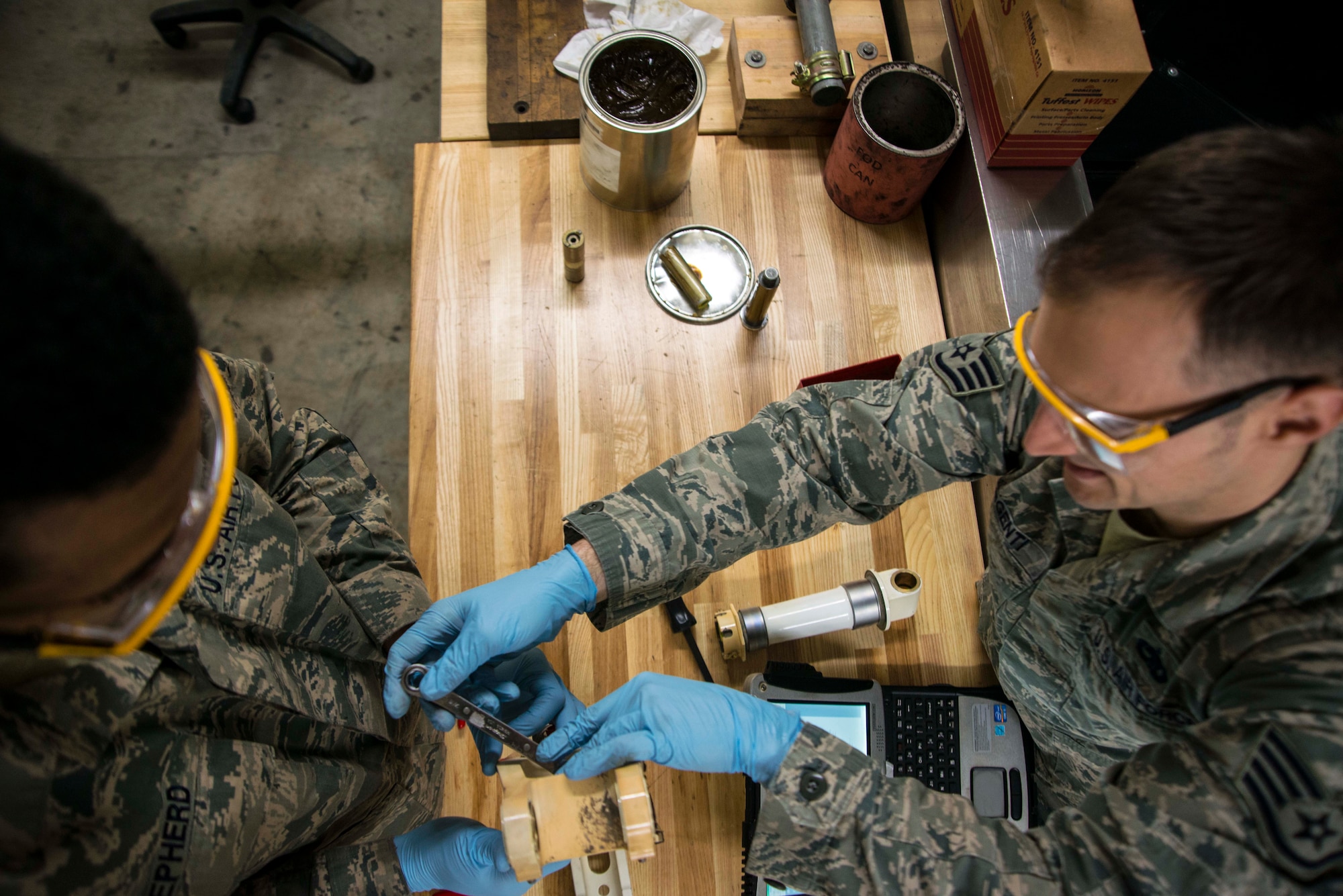 Senior Airman Rodney Shepherd, left, and Staff Sgt. Brian Argenti, 35th Maintenance Squadron hydraulics systems maintainers, repair an F-16 Fighting Falcon's landing gear system March 31, 2015, at Misawa Air Base, Japan. As back shop maintainers, the duo repairs parts brought to them from crew chiefs on the flightline. Once a part is repaired, it is qualified for use on any F-16 across the Air Force. (U.S. Air Force photo by Staff Sgt. Derek VanHorn/Released)