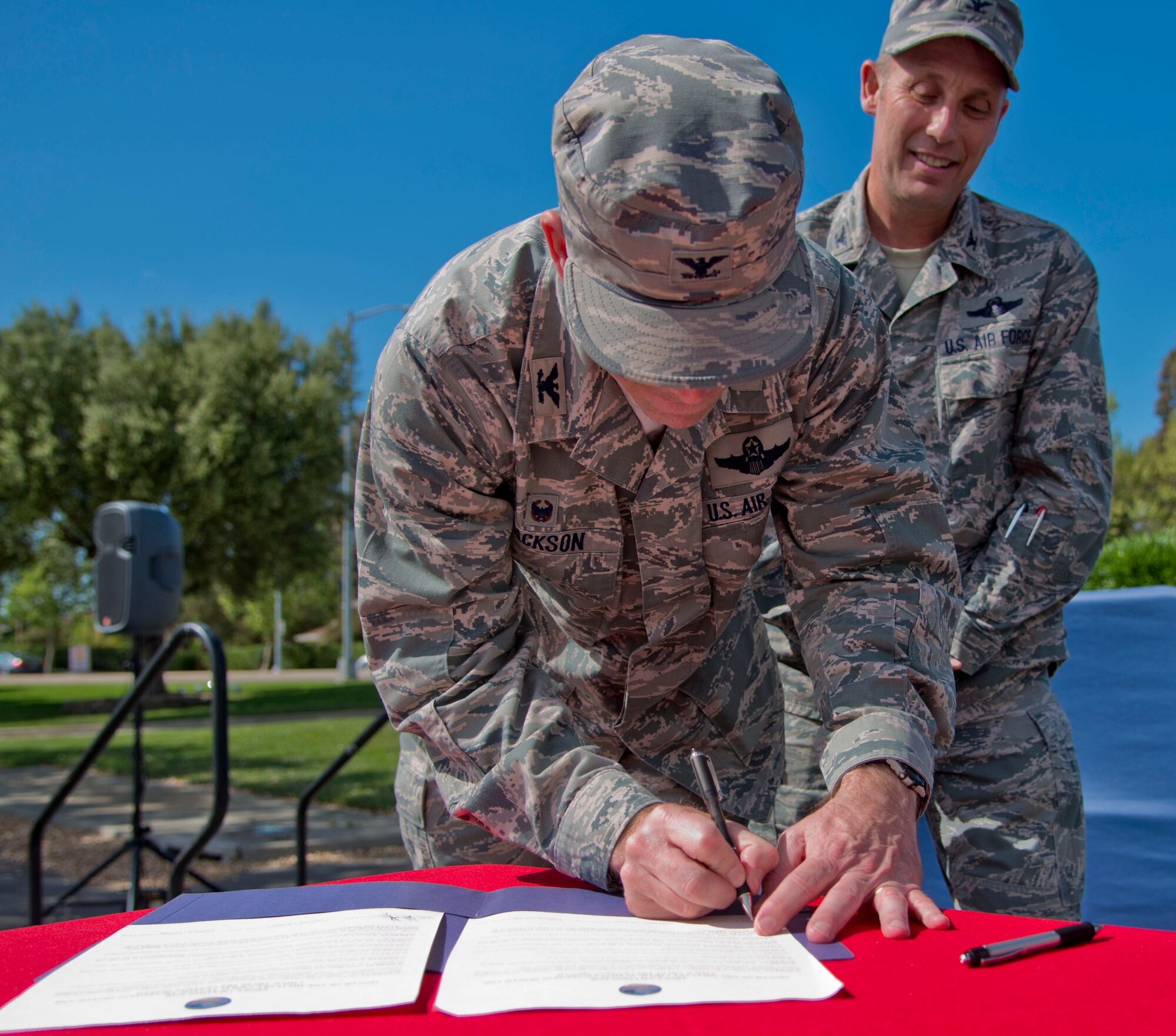 Col. Joel Jackson, 60th Air Mobility Wing commander, signs a proclamation for Month of the Military Child, Autism Awareness Month and Child Abuse Prevention Month at the kickoff of the Family Fun Fest in the Airman and Family Readiness Center parking lot on Travis Air Force Base, California April 1. Col. Matthew Burger, 349th Air Mobility Wing commander, and Lt. Col. Jeanine McAnaney, representing the 621st Contingency Response Wing  commander, also signed the proclamation. The proclamation also paid tribute to military children, acknowledging their commitment, support and sacrifices as their parents serve in the armed services. (U.S. Air Force photo/Senior Airman Nicole Leidholm)