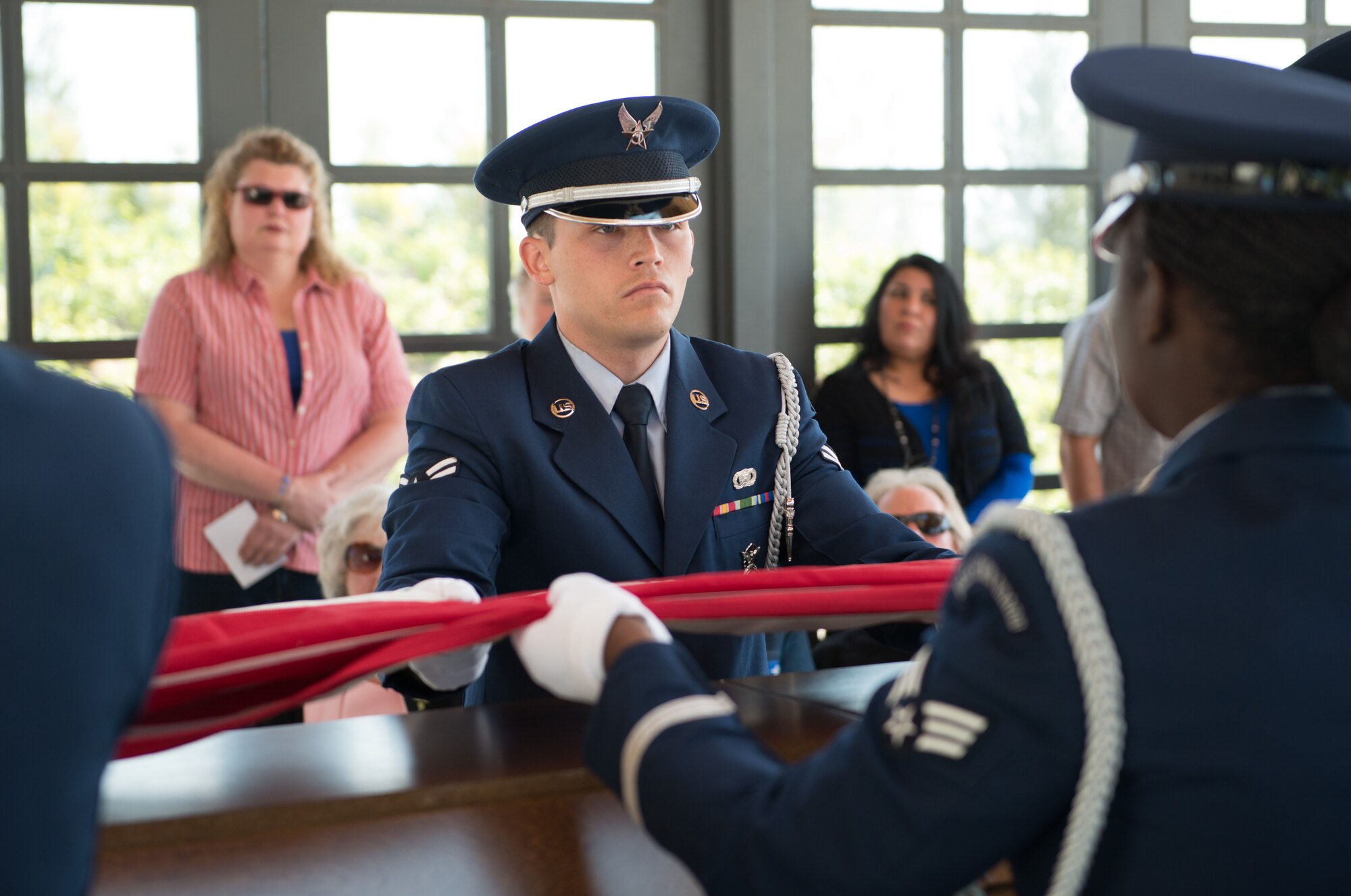 Airman 1st Class Robert Cook, Travis Honor Guard, helps fold an American flag for the family of Master Sgt. Robert Foster, a World War II veteran and former prisoner of war. Foster passed away recently and was interred in a moving ceremony at the Sacramento Valley National Cemetery in Dixon, California on March 31, 2015.  (U.S. Air Force photo/Ken Wright)

