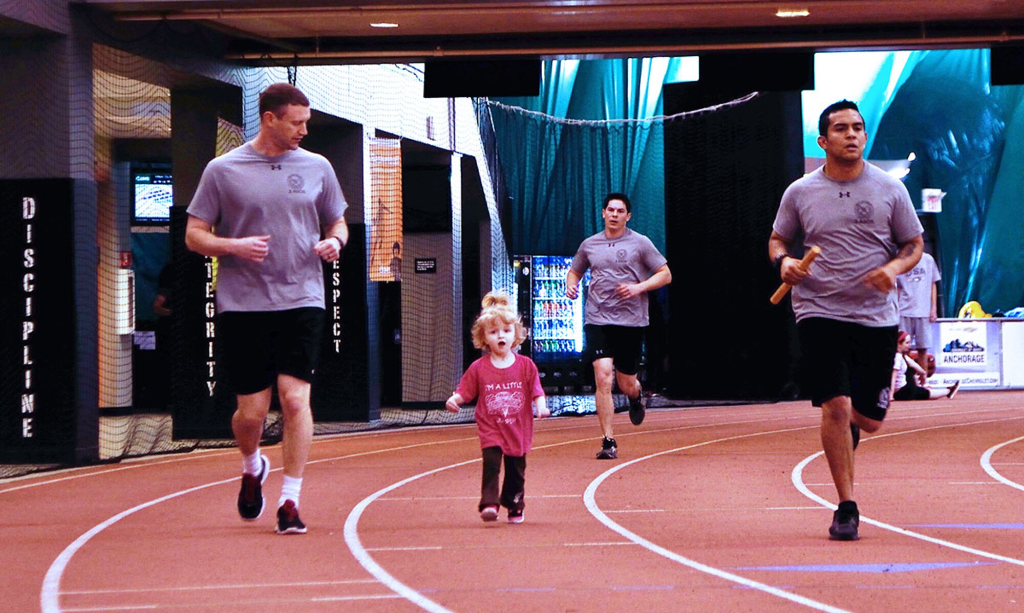 Air Force Maj. Matthew Kaercher (left), 3rd Air Support Operations Squadron director of operations, runs alongside his two-year-old daughter, Brynn, during the annual 24-hour run challenge inside the Alaska Dome in Anchorage March 26. The 24-hour run challenge is an ASOS tradition across the Air Force honoring the 10 TACPs who were killed in combat and training operations in the last 20 years. (U.S. Air Force photo/Staff Sgt. Sheila deVera)