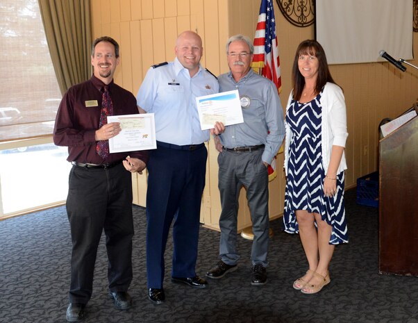 Scott Thompson (left) and Lt. Col. Jon Rucker, 9th Force Support Squadron commander, receive donations from members of the Marysville Rotary Club at the Peach Tree Golf and Country Club, Marysville, Calif., Mar. 31, 2015. The club and the Rotary Foundation combined to donate $20,000 to Beale Air Force Base Agencies. (U.S. Air Force photo by John Schwab/Released) 