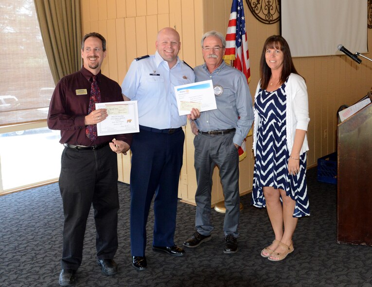 Scott Thompson (left) and Lt. Col. Jon Rucker, 9th Force Support Squadron commander, receive donations from members of the Marysville Rotary Club at the Peach Tree Golf and Country Club, Marysville, Calif., Mar. 31, 2015. The club and the Rotary Foundation combined to donate $20,000 to Beale Air Force Base Agencies. (U.S. Air Force photo by John Schwab/Released) 
