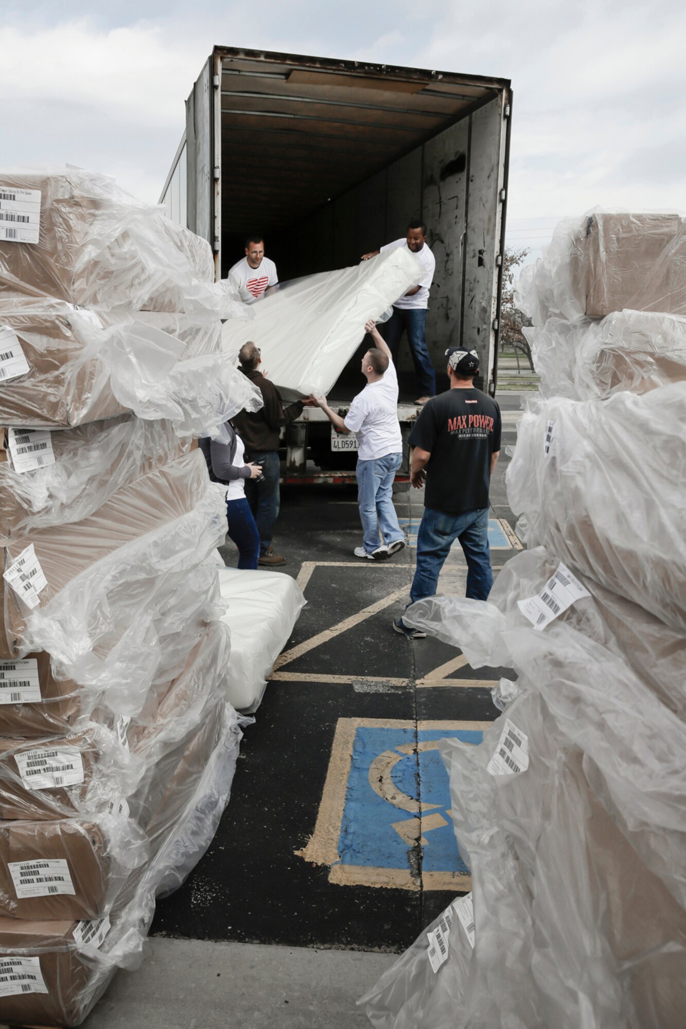 Members of the 138th Fighter Wing (FW) unload a semi-truck of bed frames and mattresses March 29, 2015, at the Ronald McDonald House of Tulsa.  Volunteers from the 138th Fighter Wing assisted at the house upon the arrival of a large shipment new beds and mattresses. (U.S. National Guard photo by Master Sgt. Mark A. Moore/Released)