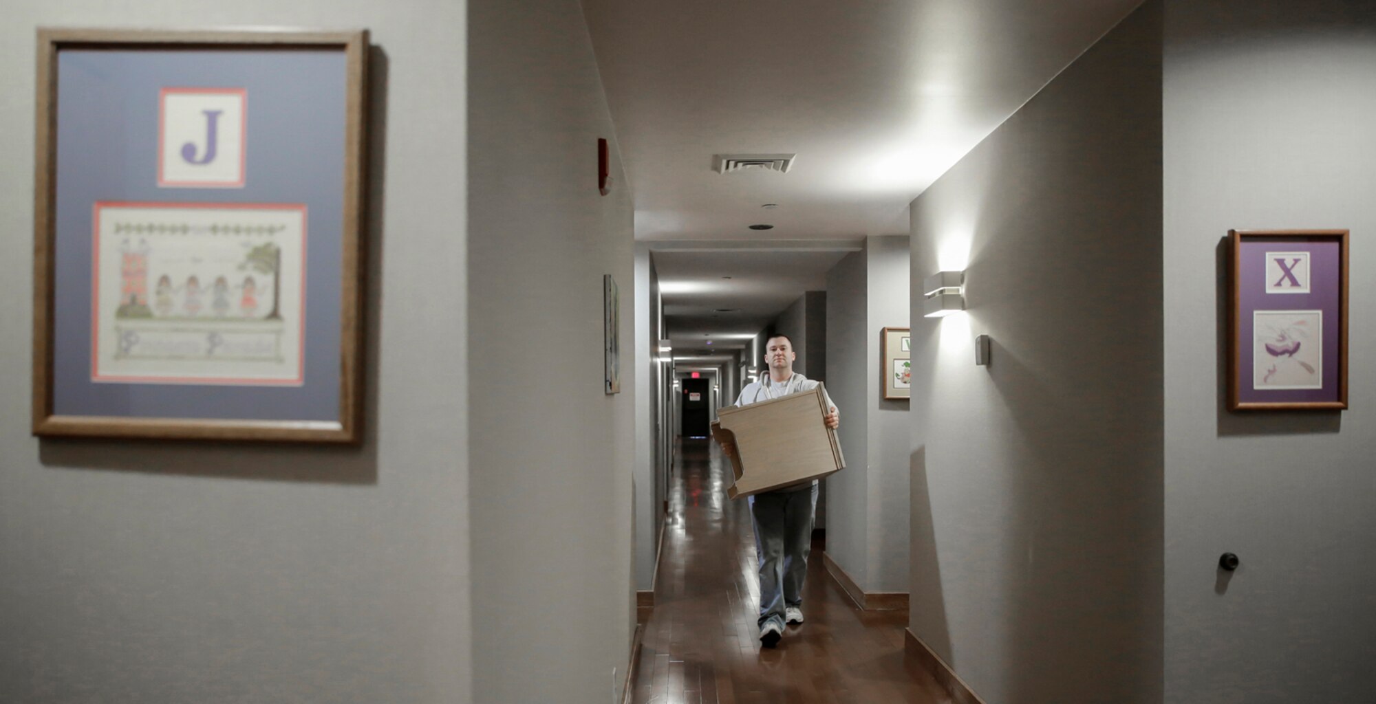 Master Sgt. Matt Wilson, 138th Civil Engineering Squadron, carries a night stand from one room to another March 29, 2015, at the Ronald McDonald House of Tulsa.  Volunteers from the 138th Fighter Wing assisted at the house upon the arrival of a large shipment new beds and mattresses. (U.S. National Guard photo by Master Sgt. Mark A. Moore/Released)