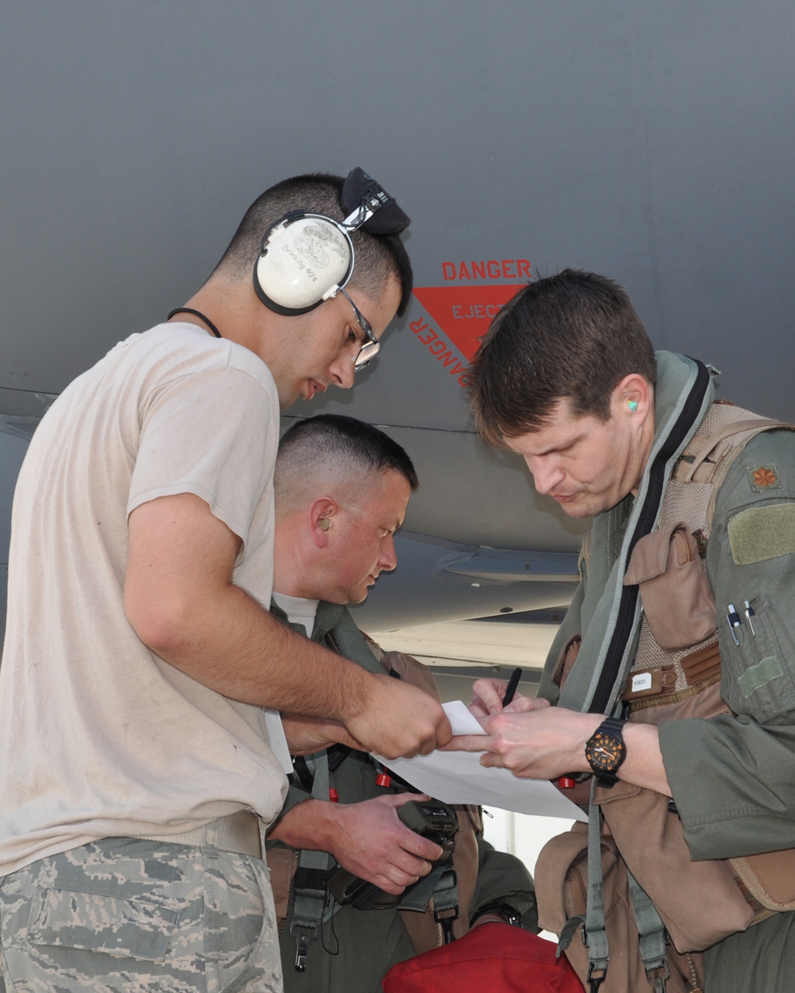 U.S. Air Force Lt. Col. Jimmy Jackson, 93rd Bomb Squadron and Maj. Landon Bell, 343rd Bomb Squadron, confer with a 2nd Bomb Wing maintainer during the preflight next to the aircraft taking  part in  a command directed exercise named ”Polar Growl”. This long range exercise is over the Arctic and North Sea regions. These bomber missions provide unique opportunities to integrate and train with Geographic Combatant Commands and our Allies and partners in joint and coalition operations and exercises. (U.S. Air Force photo by Master Sgt. Laura Siebert/Released)