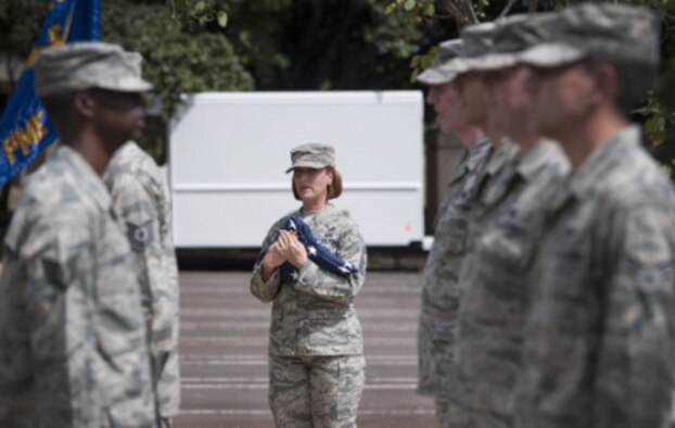 U.S. Air Force Chief Master Sgt. Laura Noel, 15th Wing Binnicker Professional Military Education (PME) Center commandant, holds the American flag during a retreat ceremony as part of a remembrance ceremony honoring the life and service of ninth Chief Master Sgt. of the Air Force James Binnicker, at the Binnicker Professional Military Education (PME) Center, March 31, 2015, at Joint Base Pearl Harbor-Hickam, Hawaii. Binnicker helped lead the implementation of the Enlisted Performance Report (EPR) and worked toward getting more master sergeants admitted into the Senior NCO Academy during his tenure as chief master sergeant of the Air Force from 1986-1990. (U.S. Air Force photo by Staff Sgt. Christopher Hubenthal)