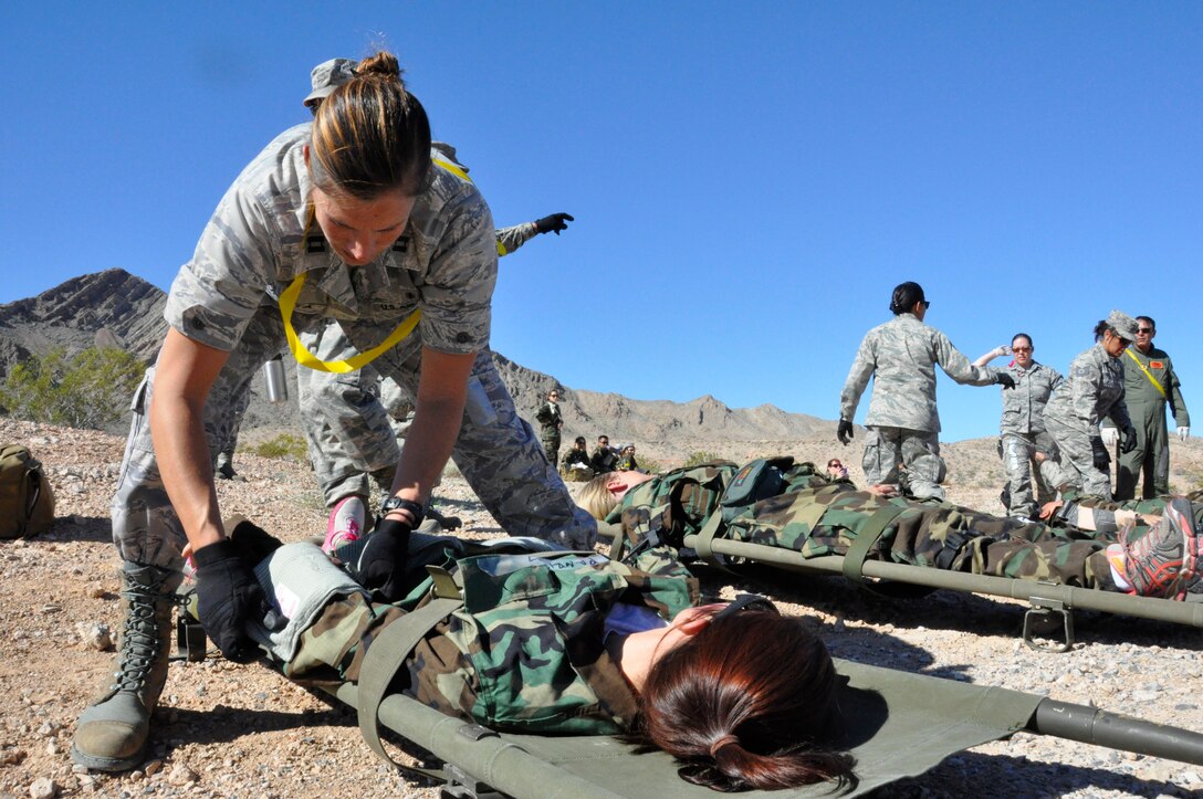 Capt. Deborah Lichota, a clinical nurse assigned to the 624th Aeromedical Staging Squadron, Joint Base Pearl Harbor-Hickam, Hawaii, applies a make-shift tourniquet to a simulated casualty during Operation Joint Medic exercise at Nellis Air Force Base, Nev., March 27, 2015. The exercise forced medical professionals to treat patients with minimal resources in a high-stress environment. (U.S. Air Force photo by Tech. Sgt. Colleen Urban)