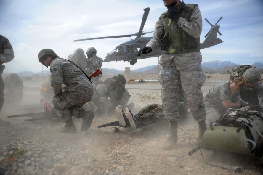 Independent duty medical technicians take cover and ready patients for medical evacuation during the Operation Joint Medic training exercise March 31, 2015, at Silver Flag Alpha range complex, Nevada. This inaugural exercise provided joint service training in preparation of full spectrum downrange medical operations. (U.S. Air Force photo by Airman 1st Class Christian Clausen/Released) 