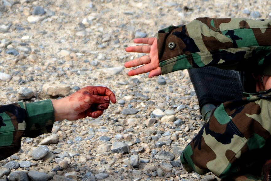 Simulated casualties console each other during the Operation Joint Medic training exercise March 31, 2015, at Silver Flag Alpha range complex, Nevada. The operation gave Army and Air Force medics a chance to not only execute and validate program skills and perform mission essential task list elements in a realistic environment, but also to interact and cooperate with medical personnel from a sister service in a joint operational environment. (U.S. Air Force photo by Airman 1st Class Christian Clausen/Released)