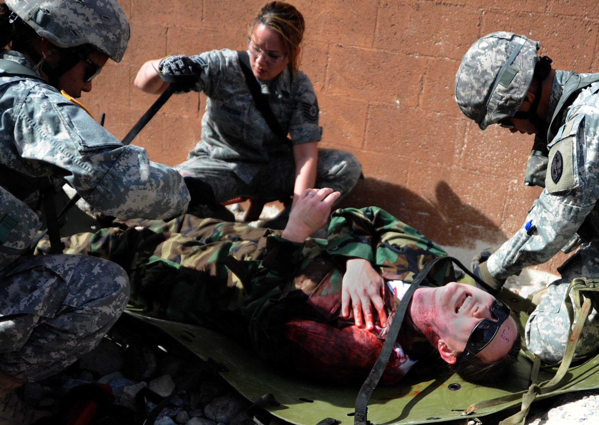 Independent duty medical technicians tend to a simulated casualty during the Operation Joint Medic training exercise March 31, 2015, at Silver Flag Alpha range complex, Nevada. The event culminated in a full-spectrum response exercise, beginning with response to combat casualties at Silver Flag, evacuation to a simulated treatment facility by helicopter and ground transport, stabilization and emergency management, and entry into the U.S. Air Force Aeromedical Evacuation System and transfer to a contingency aeromedical staging facility. (U.S. Air Force photo by Airman 1st Class Christian Clausen/Released)