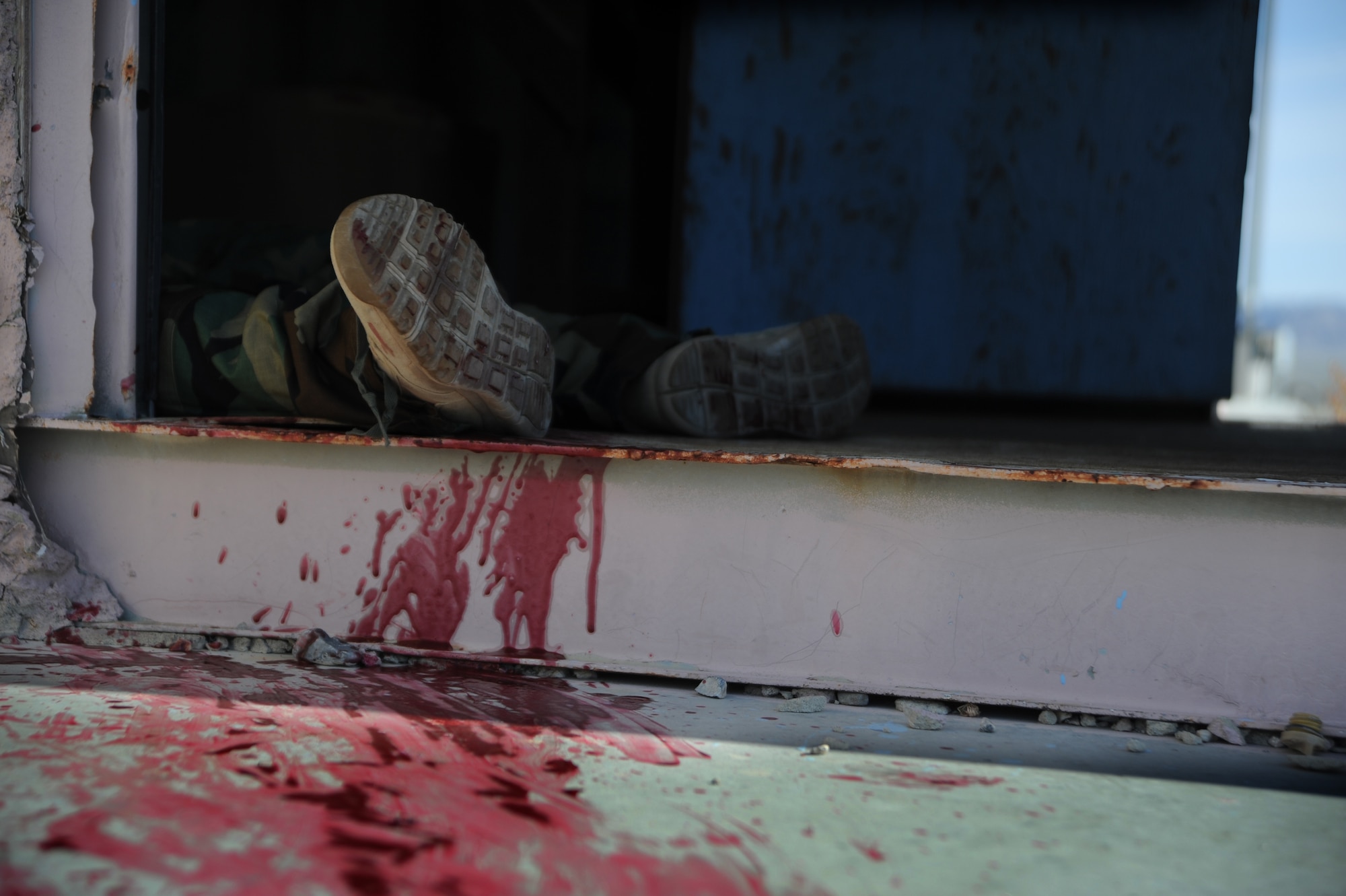 U.S. Army Specialist Dana Tamayo, Guam Army National Guard Medical Detachment member, lies in a doorway simulating a casualty during the Operation Joint Medic training exercise March 31, 2015, at Silver Flag Alpha range complex, Nevada. This inaugural exercise provided joint service training in preparation of full spectrum downrange medical operations. (U.S. Air Force photo by Airman 1st Class Christian Clausen/Released)
