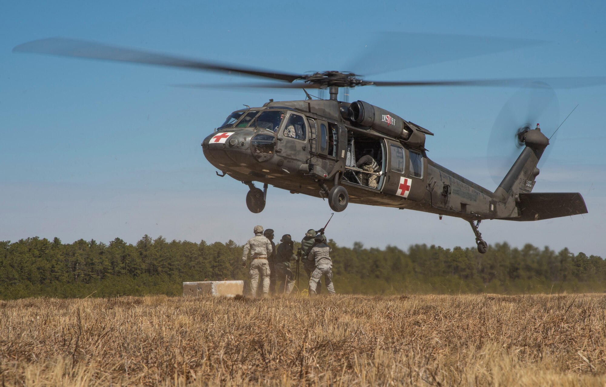 Airmen from the 621st Contingency Response Wing hook up  cargo to a U.S. Army UH-60 Black Hawk helicopter from the 1-150th Assault Helicopter Battalion during sling-load training at Joint Base McGuire-Dix-Lakehurst, N.J., April 1, 2015. The training allows the Army pilots and crew members and Air Force airmen to stay proficient with sling-load operations. (U.S. Air Force photo/Staff Sgt. Gustavo Gonzalez/RELEASED)