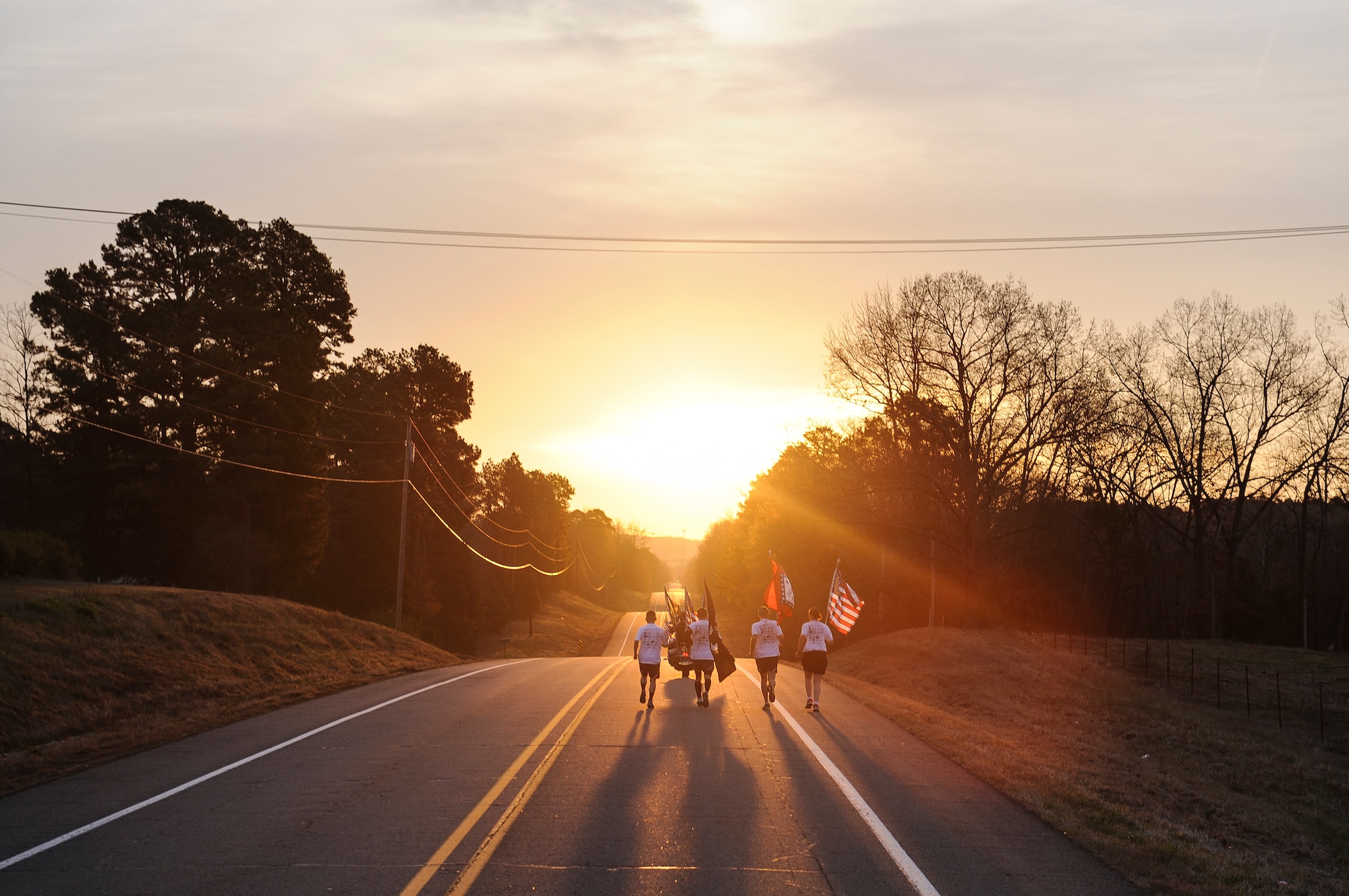 The second team of runners pick up the flags and begins their leg of the event March 20, 2015, at Altus, Ark. Twenty one, four-man-teams participated in the event by running and carrying the American flag, the Arkansas state flag, as well as a smaller American flag which had a fallen Arkansan’s bio attached to it. (U.S. Air Force photo/Senior Airman Cliffton Dolezal)