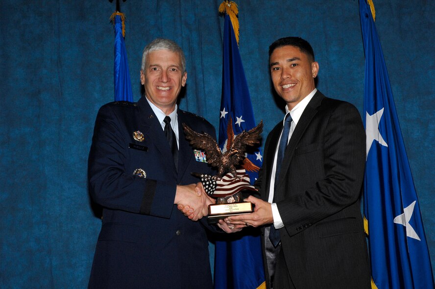 Maj. Gen. Tom Masiello, AFRL commander, presents Benjamin Tran, a member of the Silver Fang Team, with a Commander’s Cup Team award during the 2015 AFRL Annual Awards ceremony. (U.S. Air Force photo by Albert Bright)