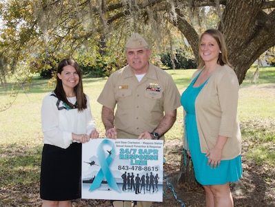 From left to right: Tiffany Mizzell, Joint Base Charleston – Weapons Station Sexual Assault Response Coordinator, CAPT Timothy Sparks, Joint Base Charleston deputy commander, and Ruby Godley, JB Charleston – Weapons Station Sexual Assault Prevention and Response civilian victim advocate, pose with a 24/7 SAPR Response Line sign April 1, 2015 at JB Charleston – Weapons Station, S.C. The theme for sexual assault awareness and prevention month this year is, “Eliminate Sexual Assault: Know your part. Do your part.” The purpose of sexual assault awareness month is to raise awareness about sexual assault prevention and support sexual assault survivors. (U.S. Air Force photo/Staff Sgt. AJ Hyatt)