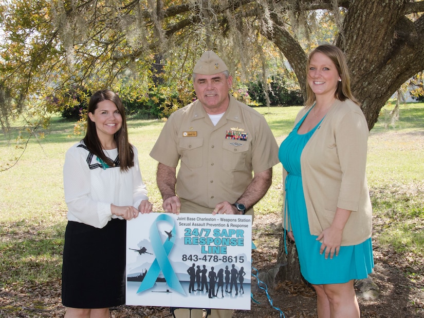 From left to right: Tiffany Mizzell, Joint Base Charleston – Weapons Station Sexual Assault Response Coordinator, CAPT Timothy Sparks, Joint Base Charleston deputy commander, and Ruby Godley, JB Charleston – Weapons Station Sexual Assault Prevention and Response civilian victim advocate, pose with a 24/7 SAPR Response Line sign April 1, 2015 at JB Charleston – Weapons Station, S.C. The theme for sexual assault awareness and prevention month this year is, “Eliminate Sexual Assault: Know your part. Do your part.” The purpose of sexual assault awareness month is to raise awareness about sexual assault prevention and support sexual assault survivors. (U.S. Air Force photo/Staff Sgt. AJ Hyatt)