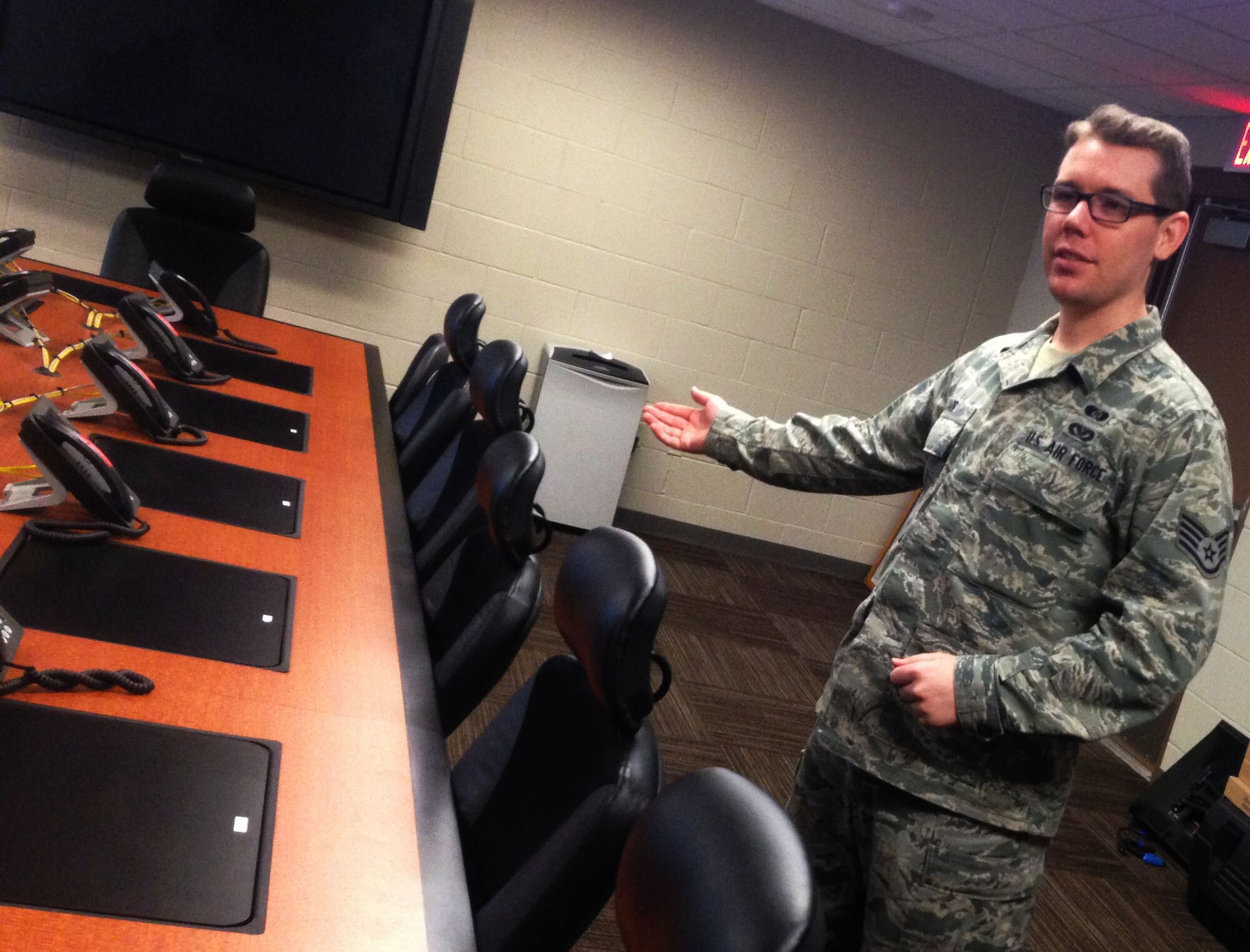 Staff Sgt. Raymond Carr, 931st Air Refueling Group emergency manager, tours the McConnell Emergency Response Conference Room here, April 2, 2015.  As temperatures rise at McConnell, so too does the likelihood of experiencing tornado.  (U.S. Air Force photo by Tech. Sgt. Abigail Klein)
