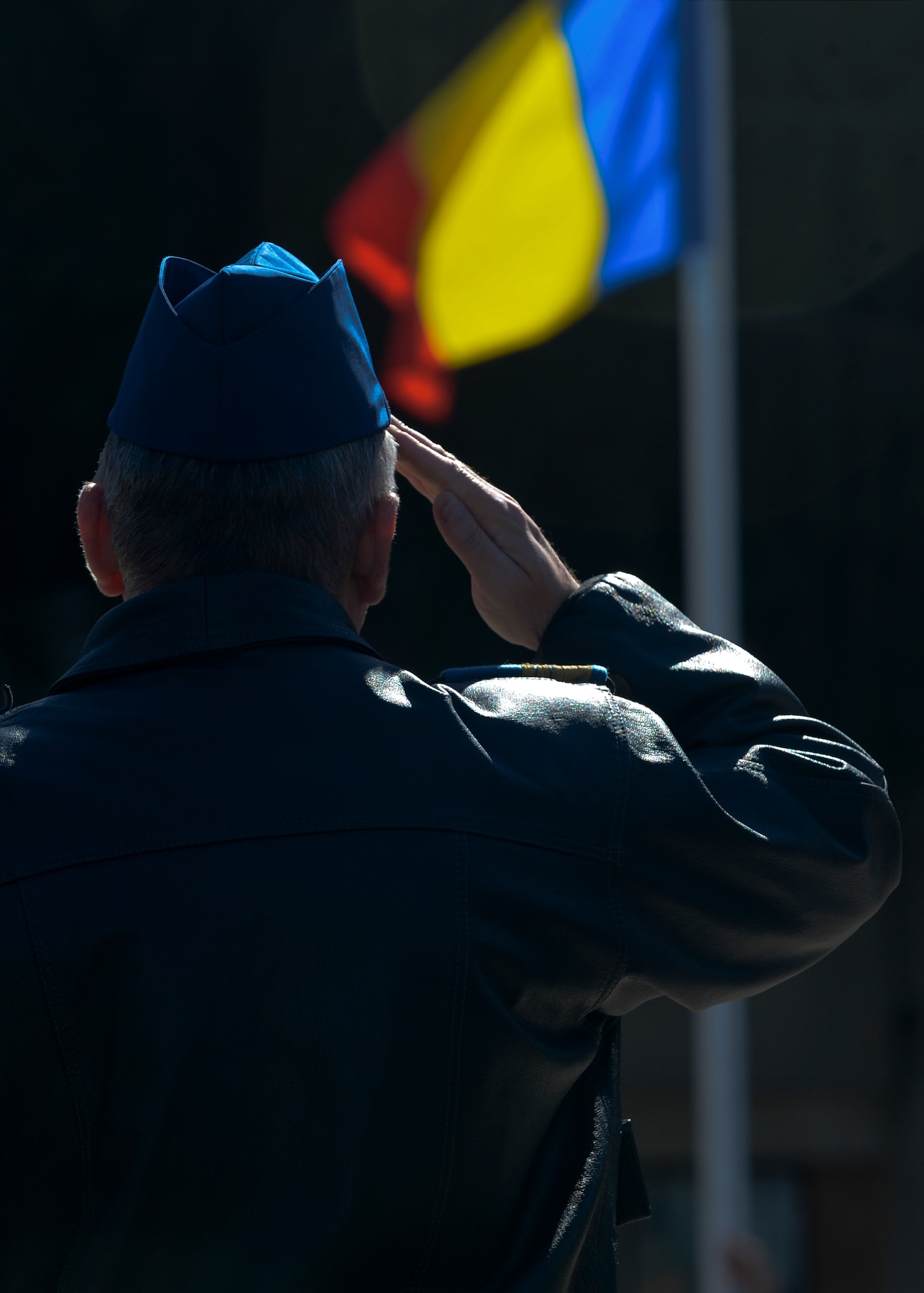 Romanian air force Capt. Cmdr. Caline Hulea, a MiG-21 aircraft pilot assigned to the 711th Fighter Squadron, salutes the raising of the Romanian flag during the opening ceremony of Dacian Thunder 2015 at Campia Turzii, Romania, April 1, 2015. The U.S. and Romanian air forces will conduct training aimed to strengthen interoperability and demonstrate the countries' shared commitment to the security and stability of Europe.  (U.S. Air Force photo by Staff Sgt. Joe W. McFadden/Released)