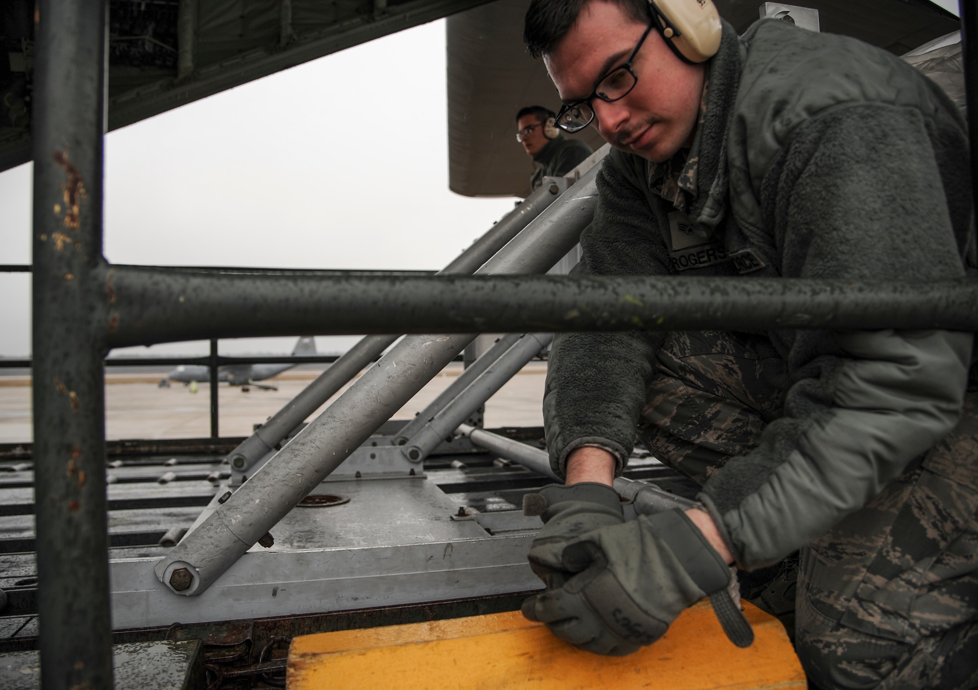 Senior Airman Stephen Rogers, a 19th Logistics Readiness Squadron air transportation specialist, secures a chock March 9, 2015, at Little Rock Air Force Base, Ark. Rogers used the chock to secure a gap between a vehicle and C-130J loading ramp, before transferring cargo. (U.S. Air Force photo by Airman 1st Class Harry Brexel)  
